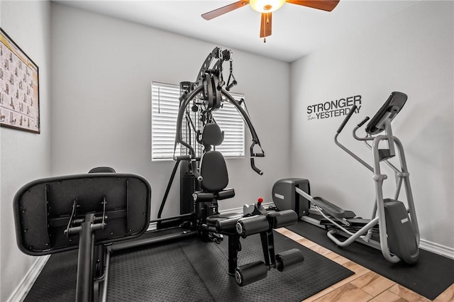 workout area featuring baseboards and ceiling fan