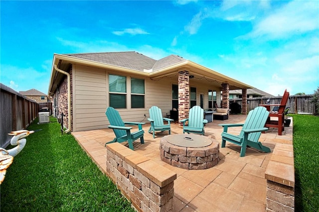 rear view of property with roof with shingles, an outdoor fire pit, a fenced backyard, a patio area, and a yard