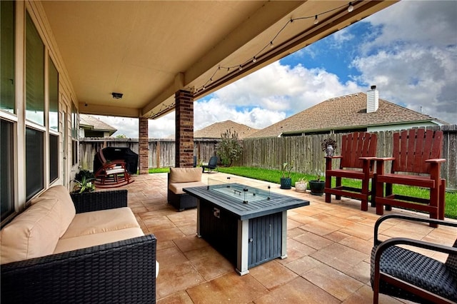 view of patio featuring a fenced backyard and an outdoor living space with a fire pit