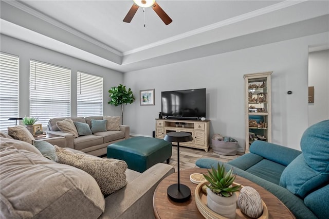living area with crown molding, baseboards, a ceiling fan, and light wood-style flooring