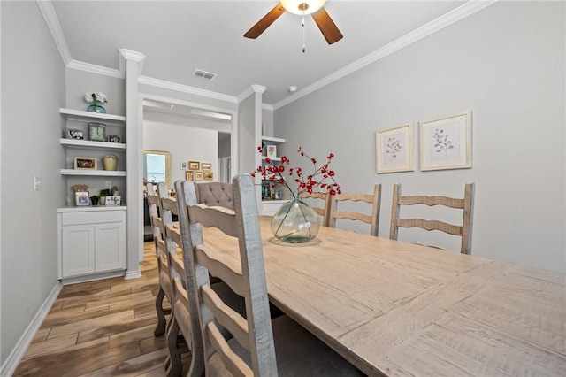 dining space featuring visible vents, crown molding, baseboards, ceiling fan, and light wood finished floors