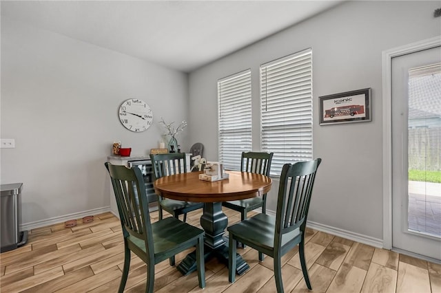 dining room featuring baseboards and light wood finished floors