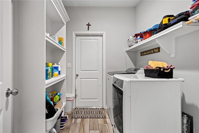laundry room with laundry area, independent washer and dryer, and wood finished floors