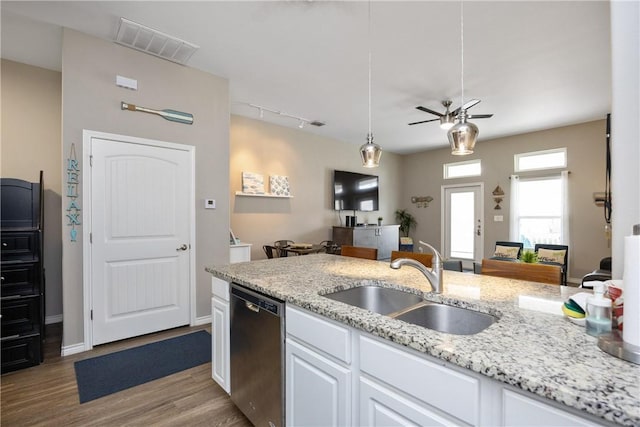 kitchen with visible vents, white cabinets, dishwasher, light stone countertops, and a sink