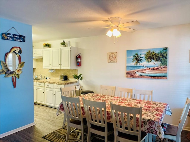 dining room with light wood-type flooring and ceiling fan