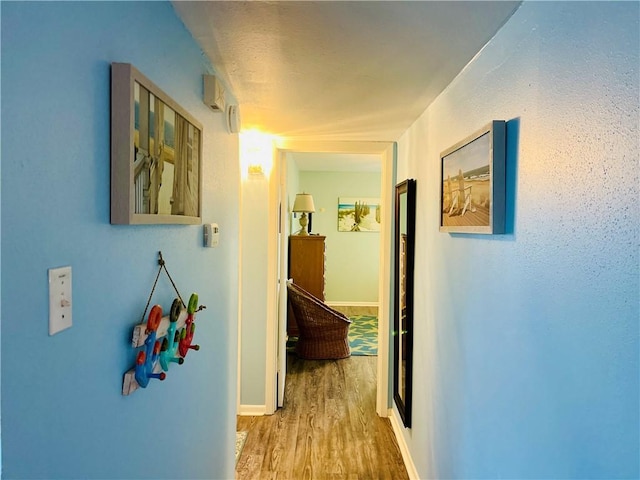 hallway with light hardwood / wood-style floors