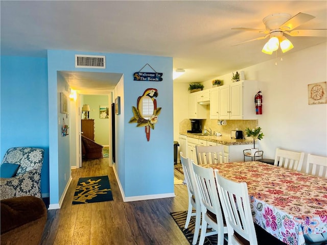 dining room with ceiling fan and dark hardwood / wood-style flooring