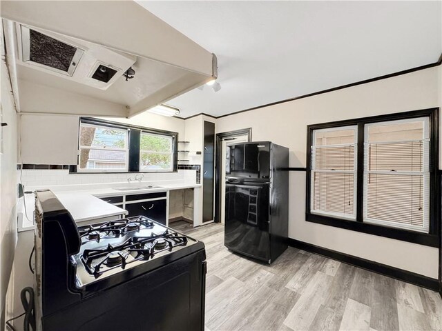 1245 Florida Ave, Corpus Christi, TX 78404 - kitchen with light countertops, light wood-style flooring, baseboards, lofted ceiling, and black appliances
