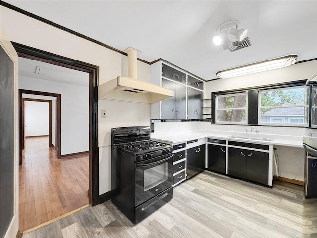 1245 Florida Ave, Corpus Christi, TX 78404 - kitchen featuring open shelves, dark cabinetry, visible vents, wall chimney range hood, and black range with gas cooktop