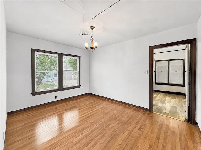 1245 Florida Ave, Corpus Christi, TX 78404 - spare room with light wood finished floors, baseboards, visible vents, and a chandelier