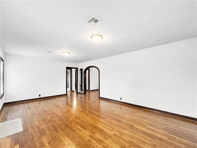 1245 Florida Ave, Corpus Christi, TX 78404 - empty room with light wood-type flooring, arched walkways, baseboards, and visible vents