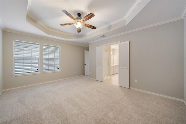 carpeted spare room with crown molding and a raised ceiling