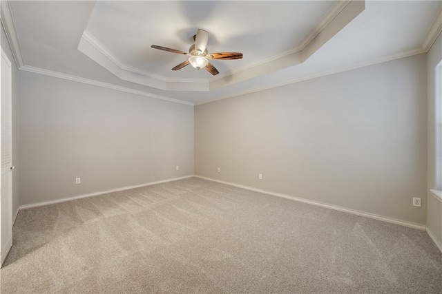 carpeted empty room featuring crown molding, ceiling fan, and a tray ceiling