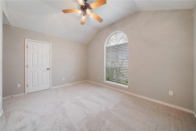 empty room with vaulted ceiling, ceiling fan, and light colored carpet