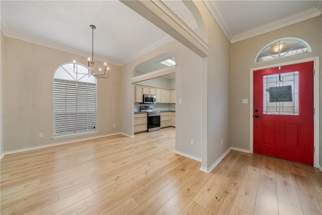 foyer with light wood-type flooring, a chandelier, and crown molding