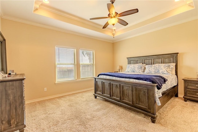 bedroom featuring ceiling fan, ornamental molding, light carpet, and a tray ceiling