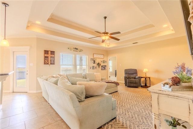 tiled living room with a raised ceiling, ceiling fan, and crown molding