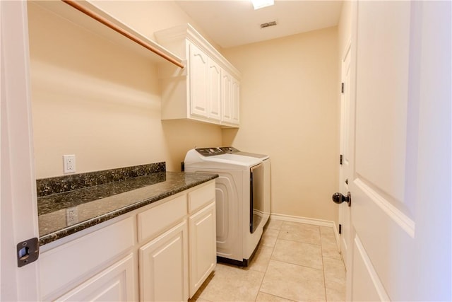 laundry area with cabinets, light tile patterned floors, and washing machine and dryer