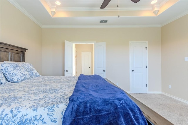 carpeted bedroom with a tray ceiling, ceiling fan, and crown molding