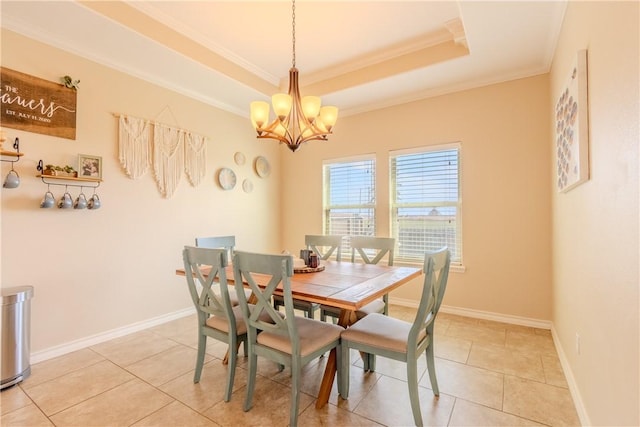 dining area featuring a tray ceiling, tile patterned floors, a notable chandelier, and ornamental molding