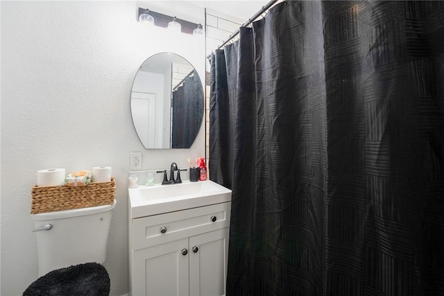 bathroom featuring curtained shower, toilet, and vanity