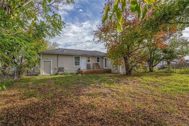 back of property featuring central AC and a yard