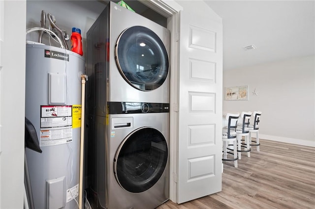 1107 E 11th St Unit H58, Port Aransas, TX 78373 - washroom featuring stacked washer / dryer, laundry area, wood finished floors, visible vents, and electric water heater