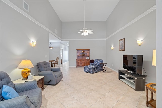 living room with light tile patterned floors, visible vents, a high ceiling, a ceiling fan, and baseboards