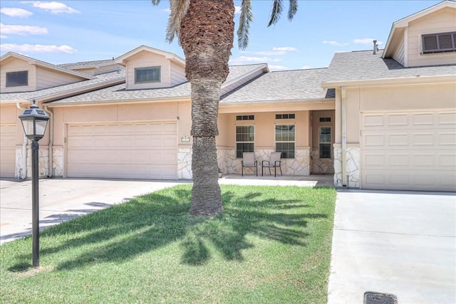 view of front of house with a garage, stone siding, a front lawn, and stucco siding