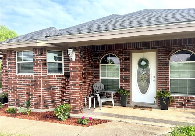 332 County Road 471, Alice, TX 78332 - view of exterior entry featuring brick siding and roof with shingles
