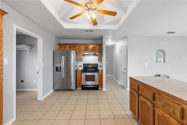 332 County Road 471, Alice, TX 78332 - kitchen with light tile patterned floors, stainless steel appliances, a tray ceiling, under cabinet range hood, and a ceiling fan