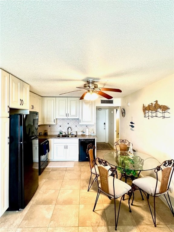 kitchen featuring white cabinets, black appliances, a textured ceiling, sink, and tasteful backsplash