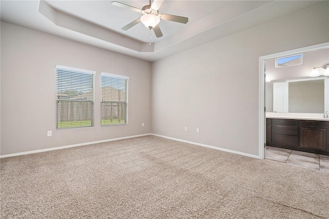 1116 Santa Catalina St, Portland, TX 78374 - unfurnished bedroom with light carpet, a tray ceiling, connected bathroom, and a ceiling fan