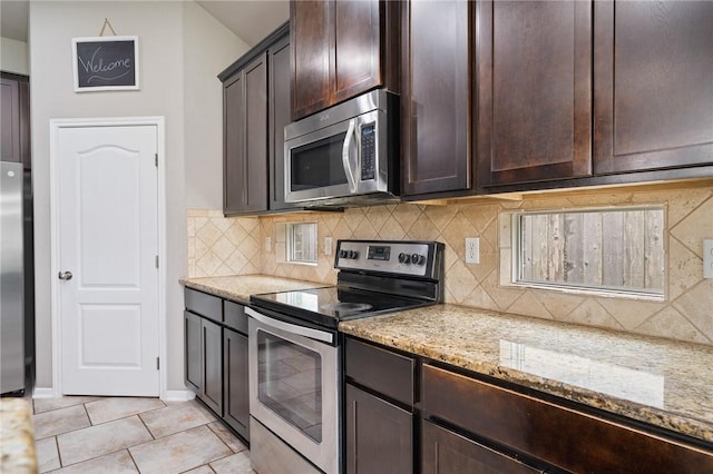 1116 Santa Catalina St, Portland, TX 78374 - kitchen featuring appliances with stainless steel finishes, dark brown cabinets, light stone countertops, light tile patterned flooring, and tasteful backsplash