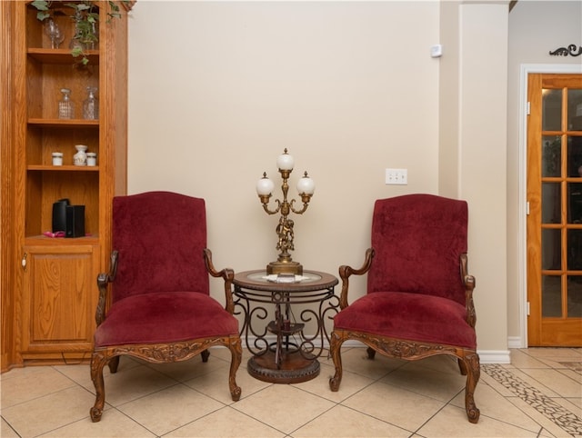 sitting room featuring a notable chandelier and light tile patterned flooring