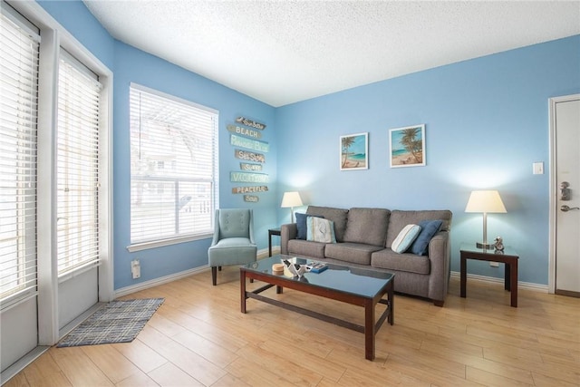 living room with a textured ceiling and light hardwood / wood-style floors