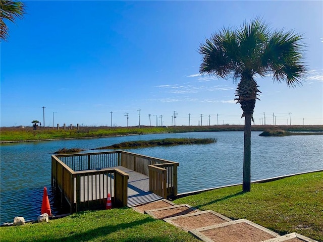 dock area with a water view and a yard