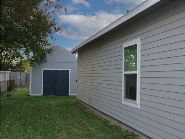 view of side of property featuring a lawn and a storage unit