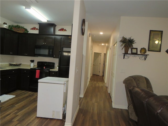 kitchen featuring black appliances and dark hardwood / wood-style floors