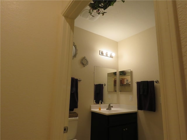 bathroom with toilet, vanity, and vaulted ceiling