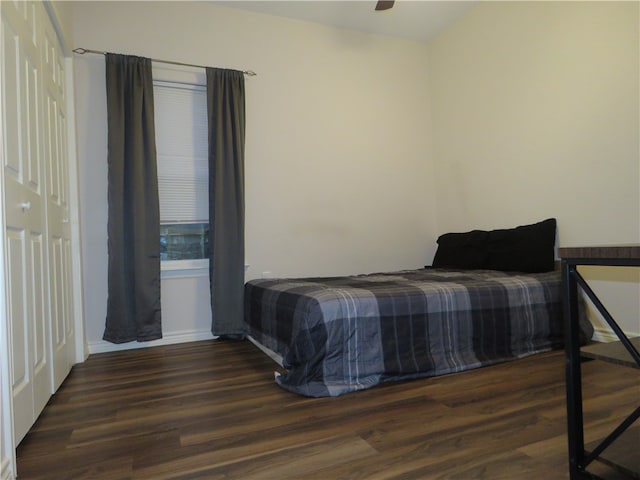 bedroom featuring dark wood-type flooring, a closet, and ceiling fan