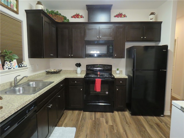 kitchen with dark brown cabinets, light hardwood / wood-style flooring, black appliances, and sink