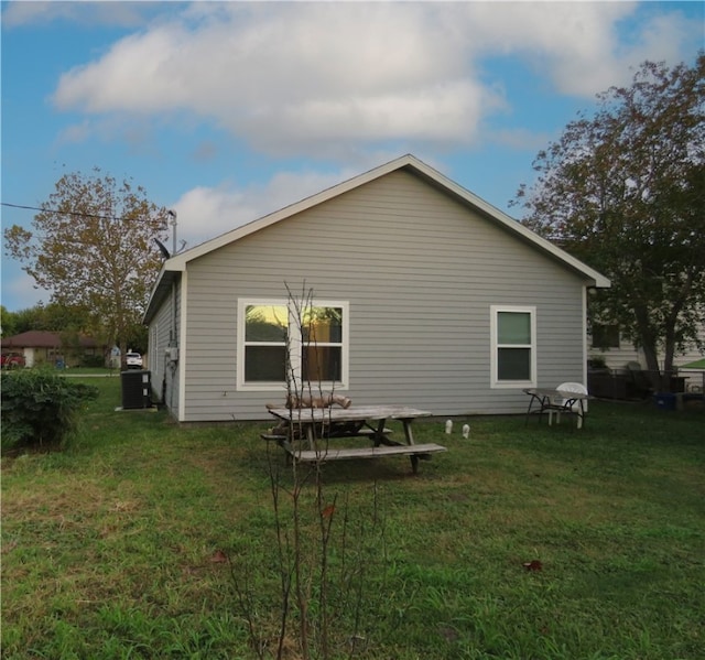 view of side of home with a lawn and cooling unit