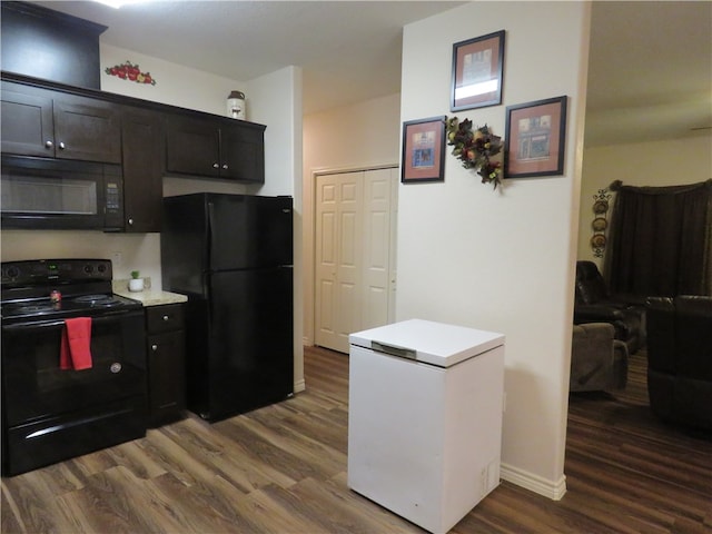 kitchen with black appliances and dark hardwood / wood-style floors