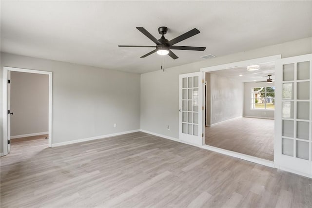 empty room featuring french doors, light wood-type flooring, and ceiling fan