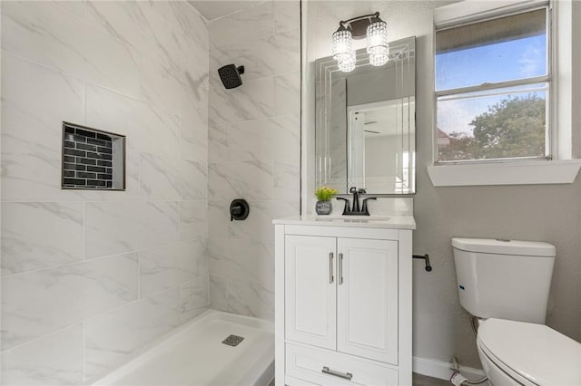 bathroom featuring vanity, toilet, and a tile shower