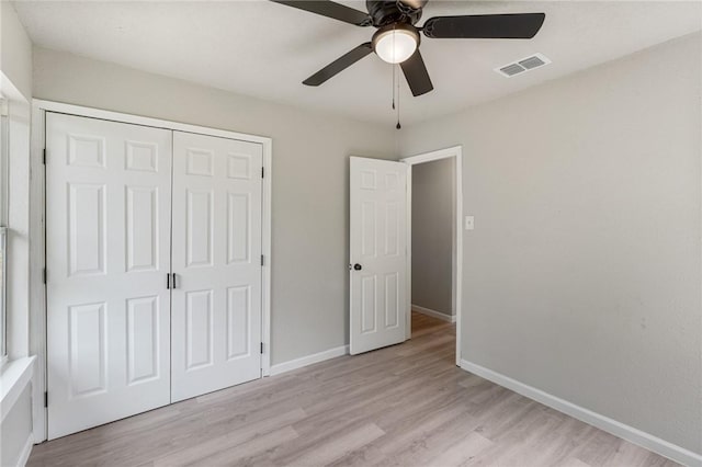 unfurnished bedroom with ceiling fan, a closet, and light hardwood / wood-style floors