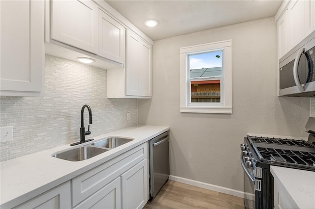 kitchen featuring sink, white cabinets, stainless steel appliances, and light wood-type flooring