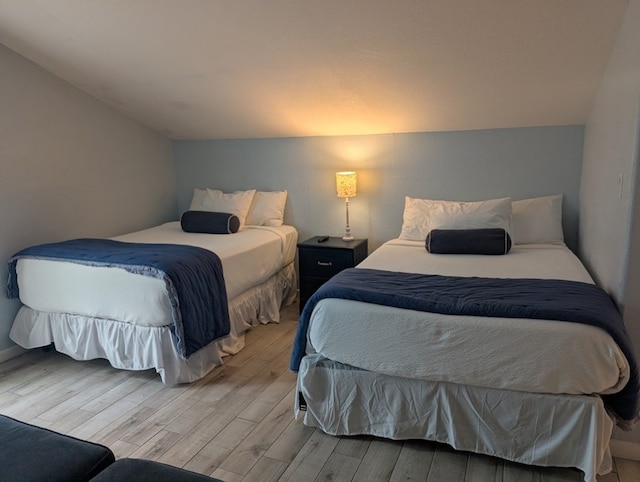 bedroom with lofted ceiling and light hardwood / wood-style floors