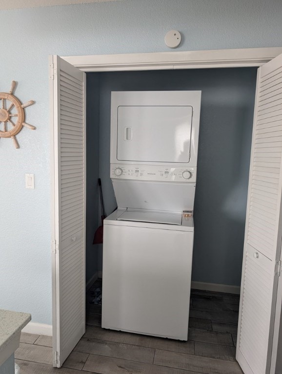 clothes washing area featuring stacked washer and clothes dryer